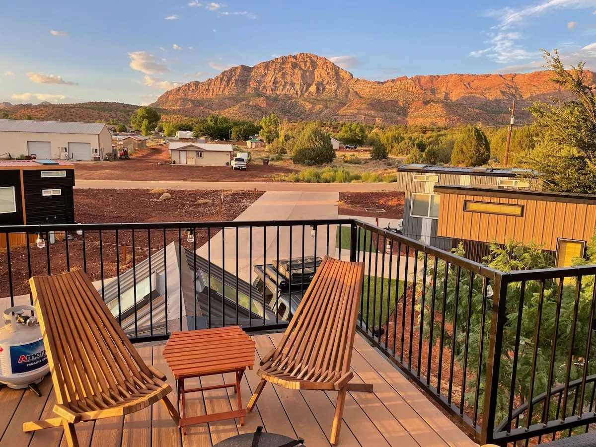 Golden-hour view of the red rock mountains from a Scarlet Horizon tiny home deck near Zion